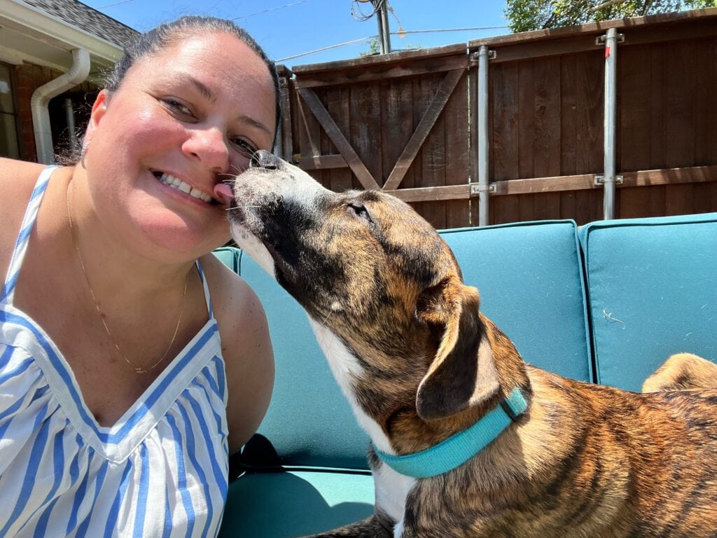 dog giving lady kisses