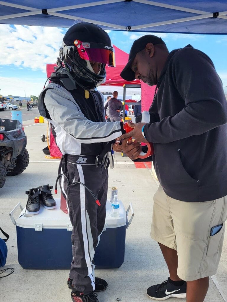 Race car driver getting wrist taped