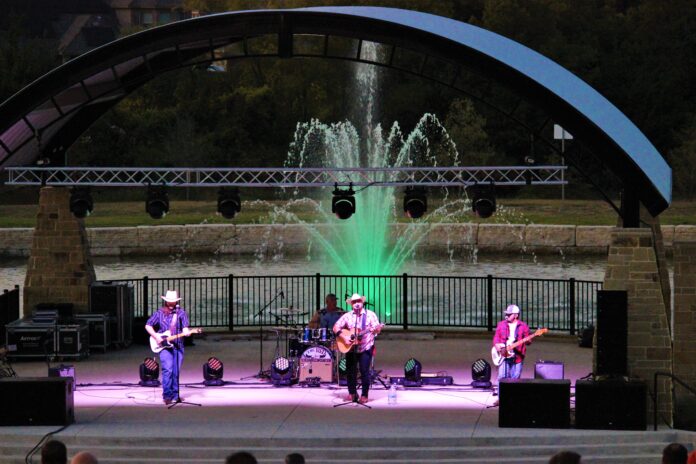 band at night with fountain behind them