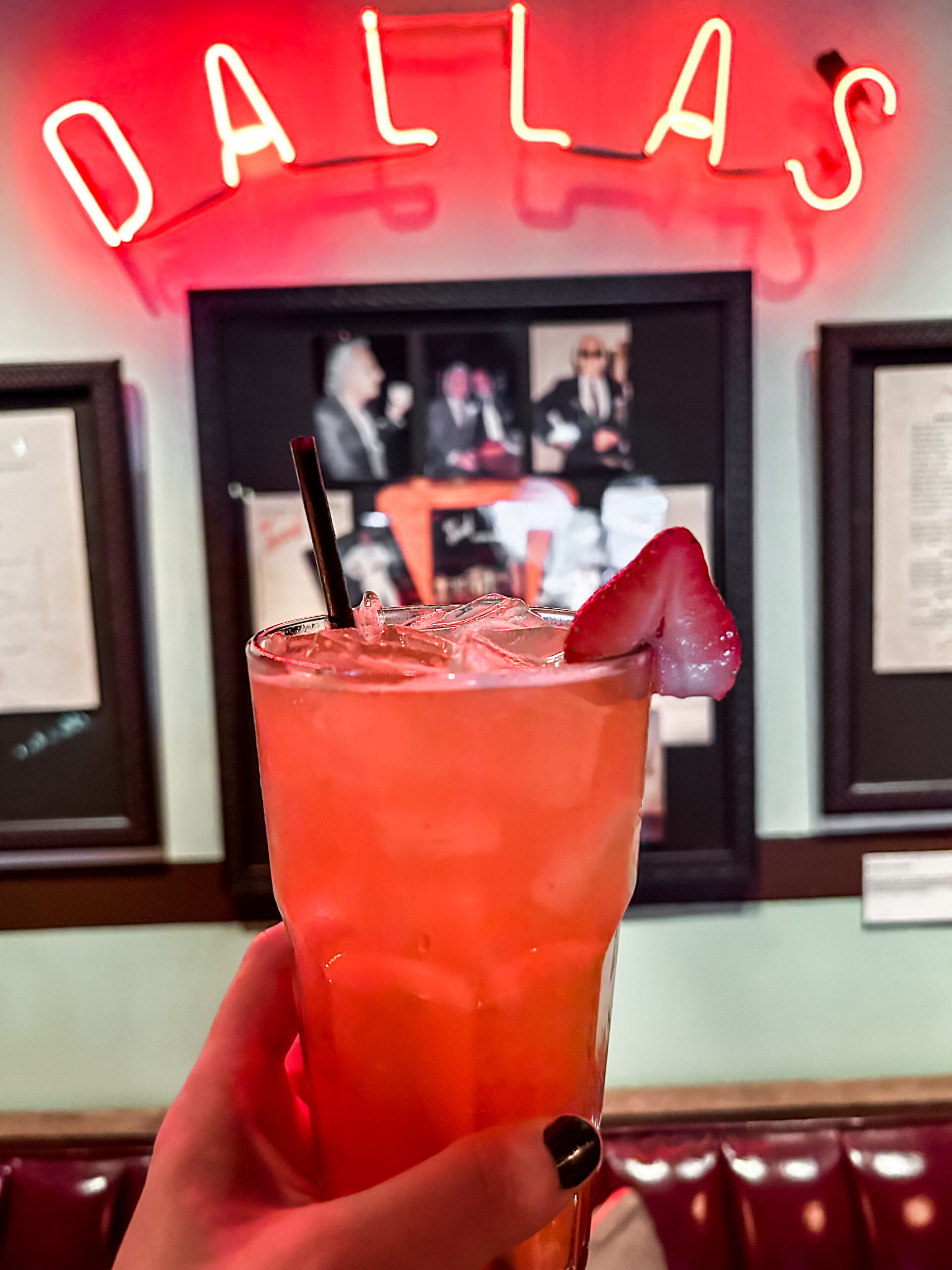 pink mocktail in glass by Dallas sign