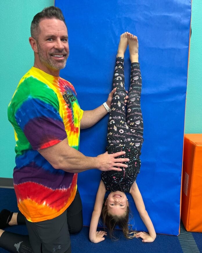 guy holding girl doing headstand