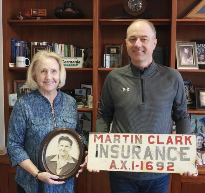 Man and woman holding a picture and sign