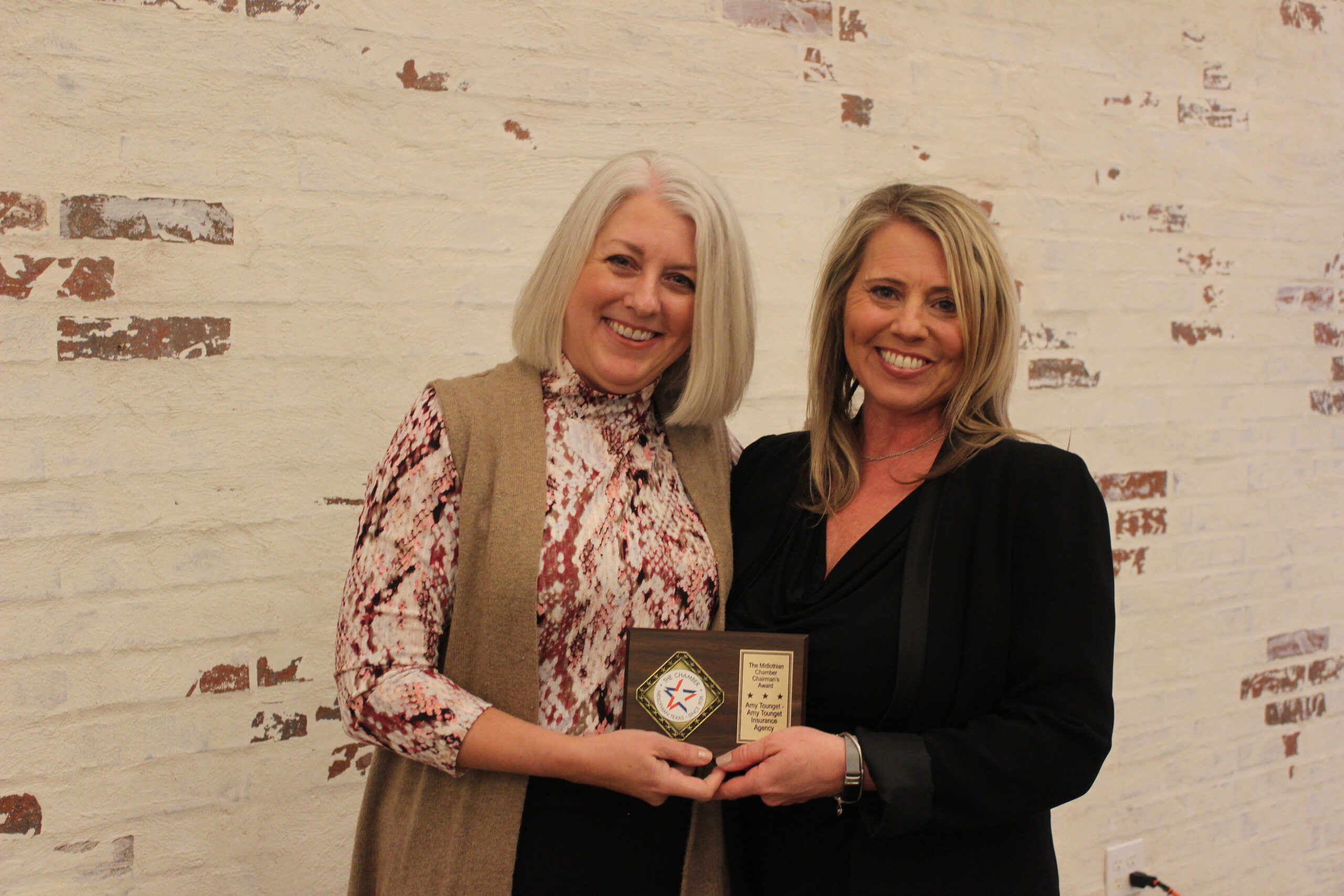 two woman holding plaque