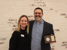 Mand and woman holding award