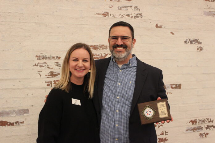 Mand and woman holding award