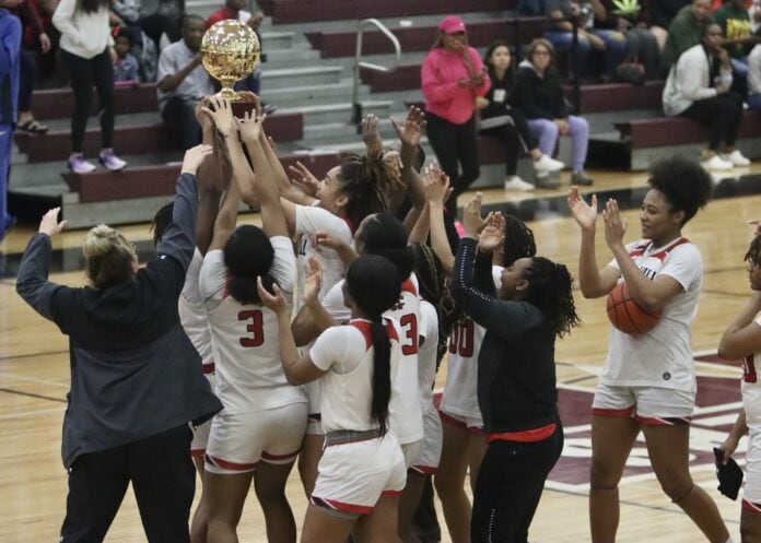 girls basketball players holding a trophy