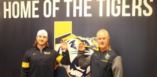 Ruzickas Make An Impact at East Texas Baptist two men by a Tigers sign