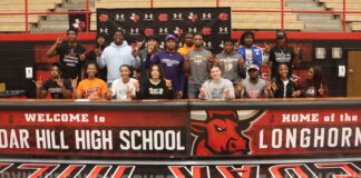 Nineteen Cedar Hill High School Seniors Sign With Colleges students athletes posing by cedar hill sign