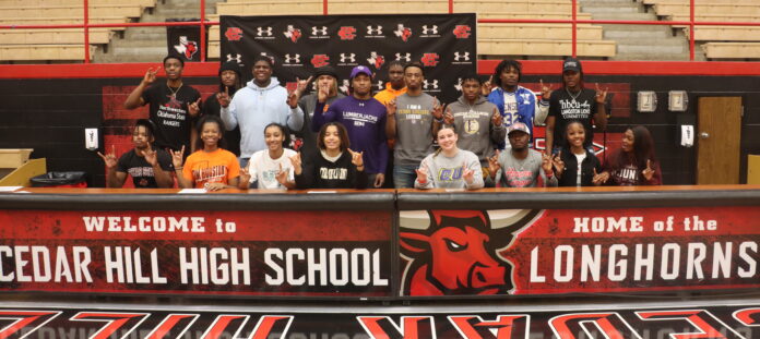 students athletes posing by cedar hill sign