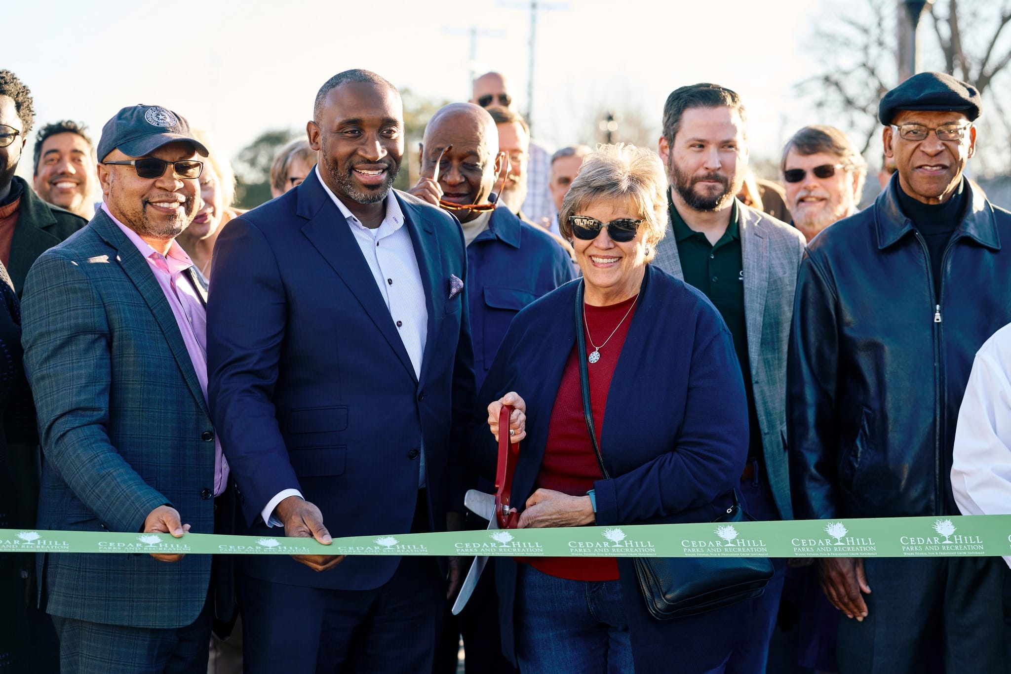 group of adults standing behind ribbon