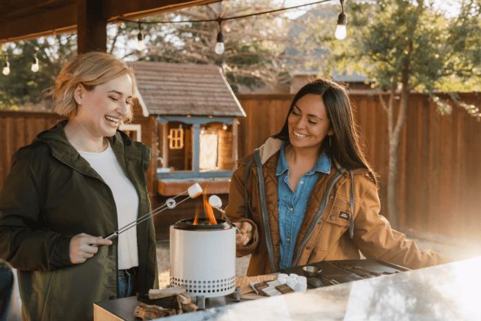 two ladies roasting marshamallows on tabletop firepit