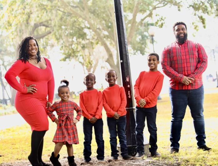 four kids and two adults all wearing red