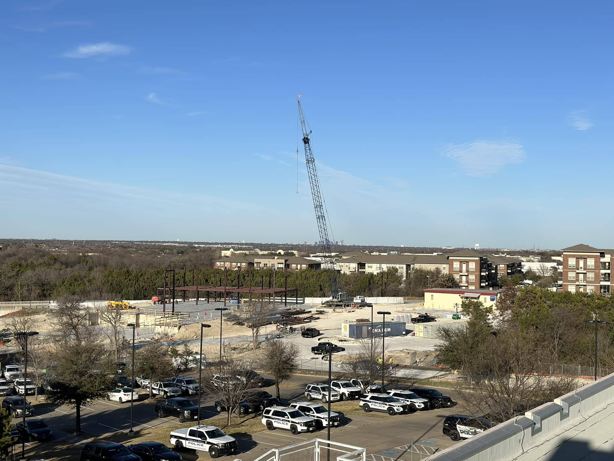 police cars in parking lot with crane in background