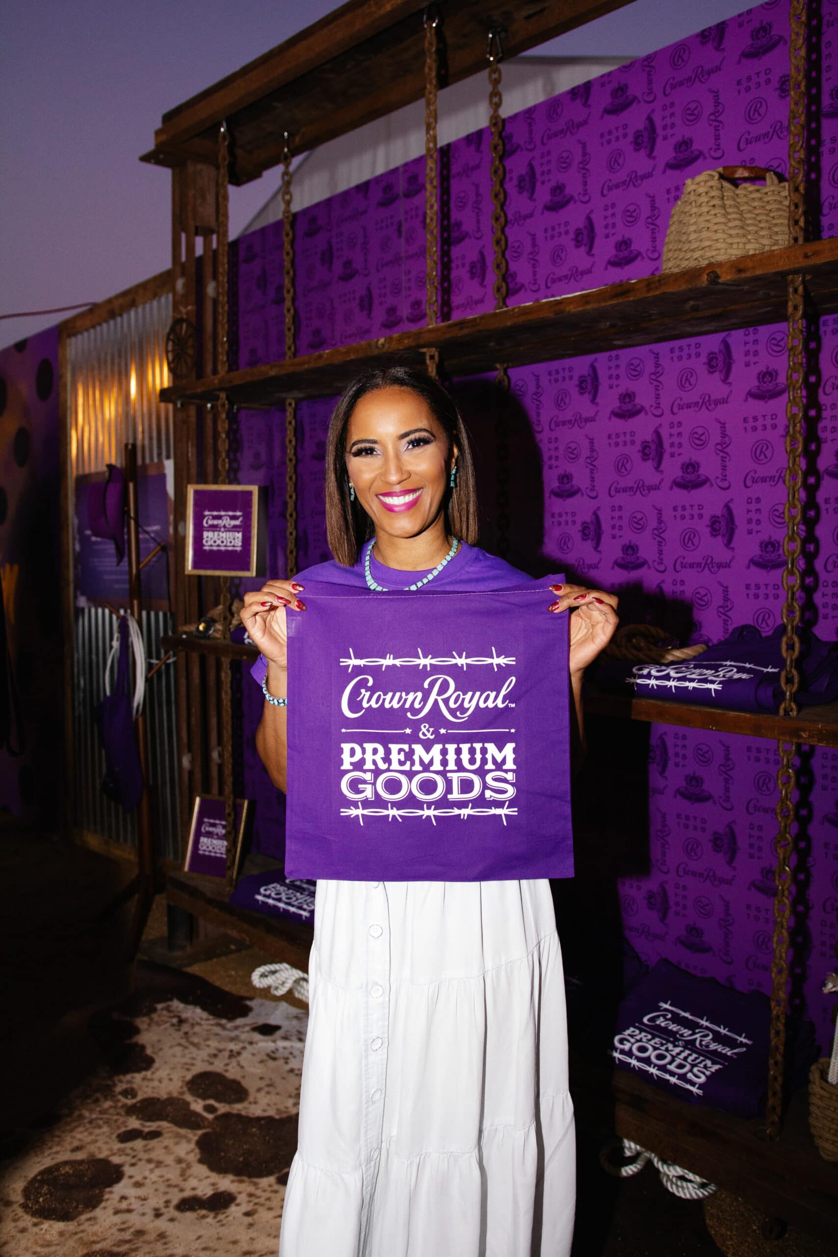 lady holding Crown Royal premium goods purple bag