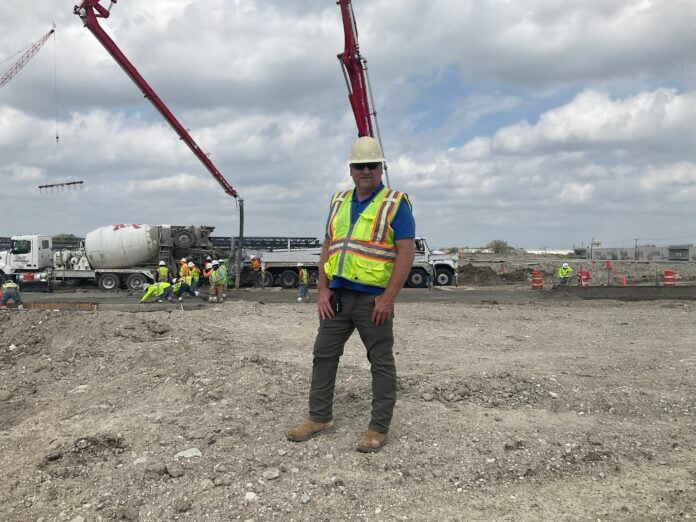 guy on construction site wearing hard hat and vest