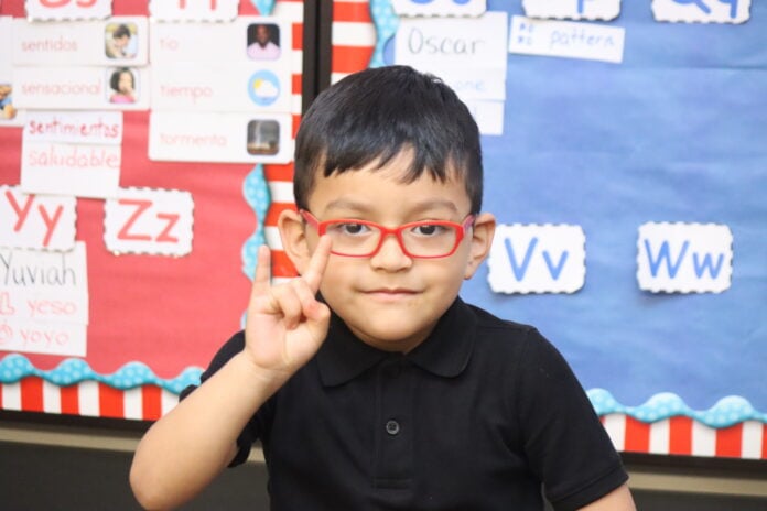 young boy wearing red glasses