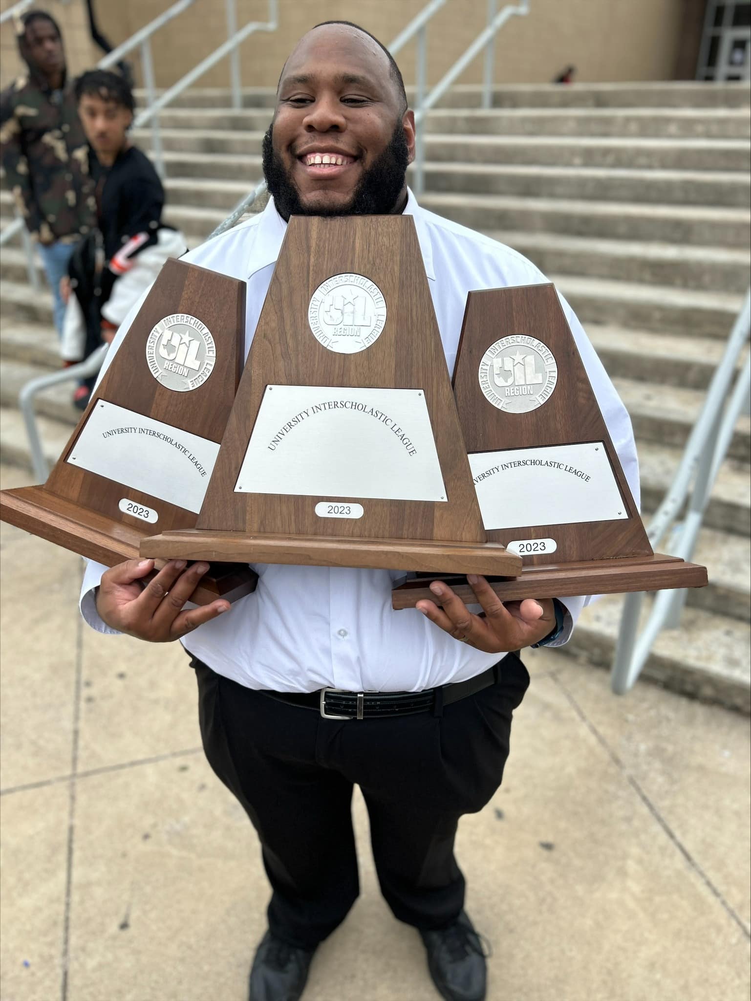 guy holding UIL trophies