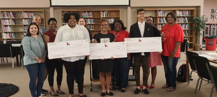 students holding cardboard checks