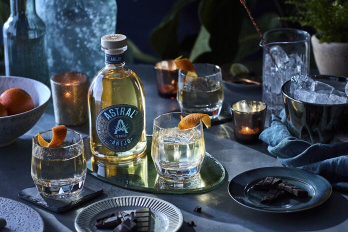 Astral Anejo tequila bottle and cocktail glasses