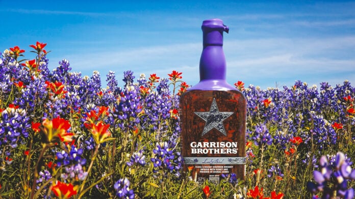 bottle of Garrison Brothers bourbon in wildflower field