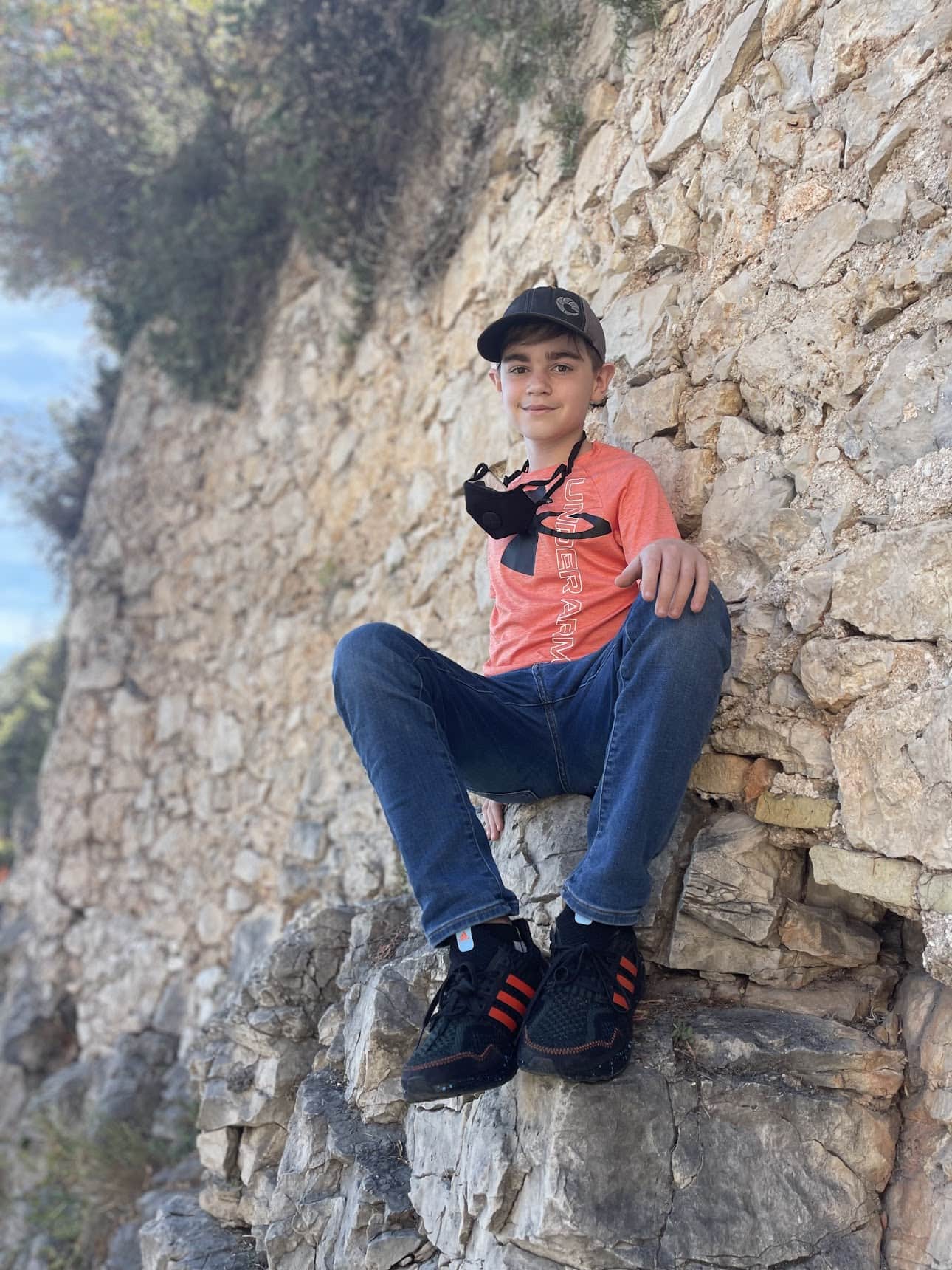 boy on sitting a rocky wall