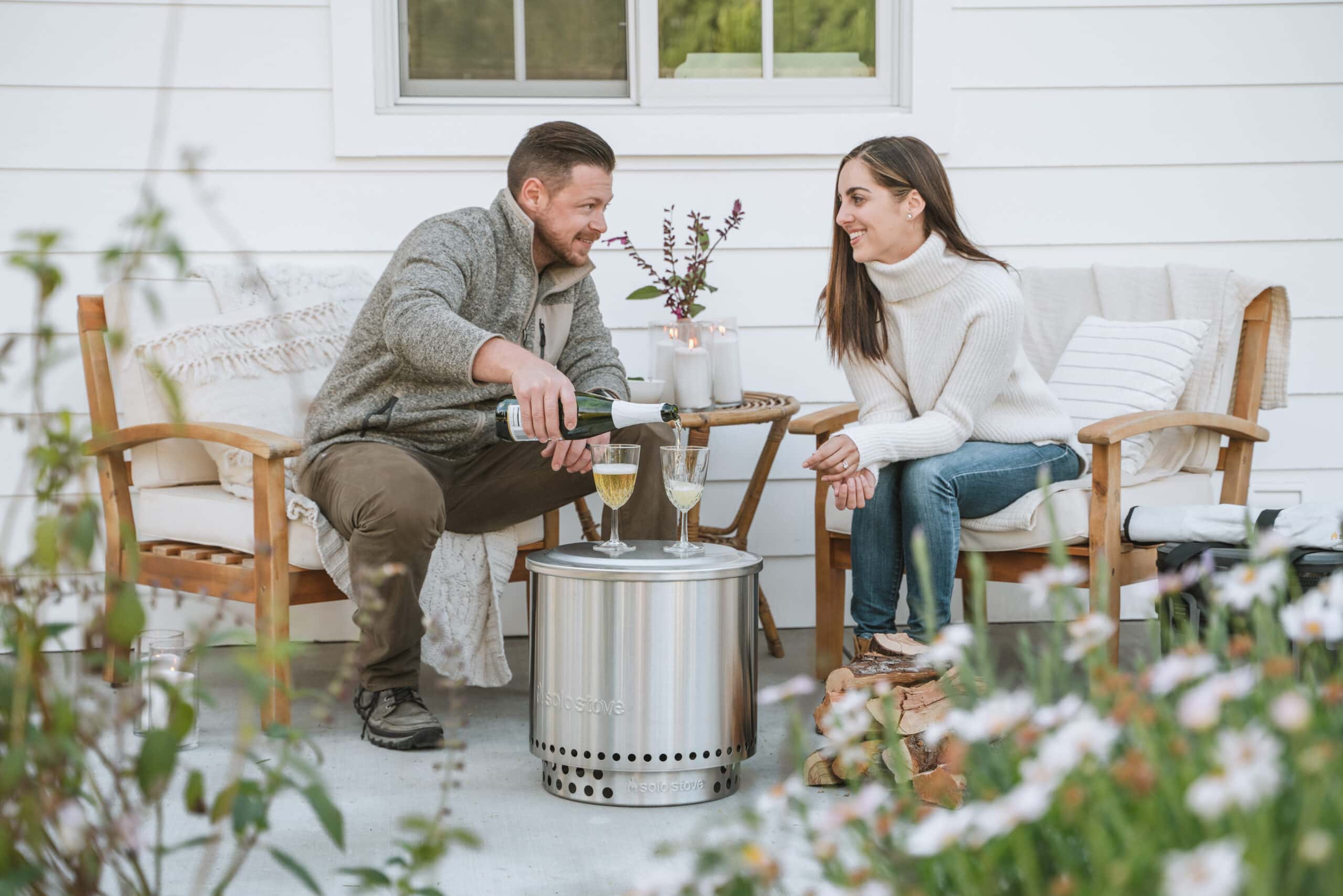 man and woman with champagne glasses on Solo Stove firepit