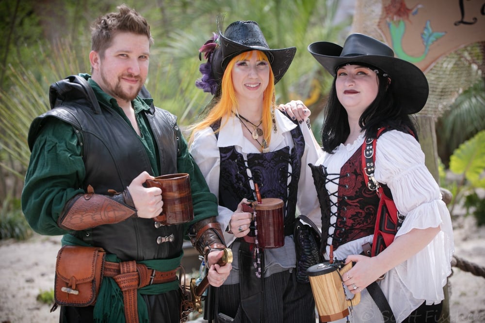 man and two women in mediaeval costumes holding beer steins