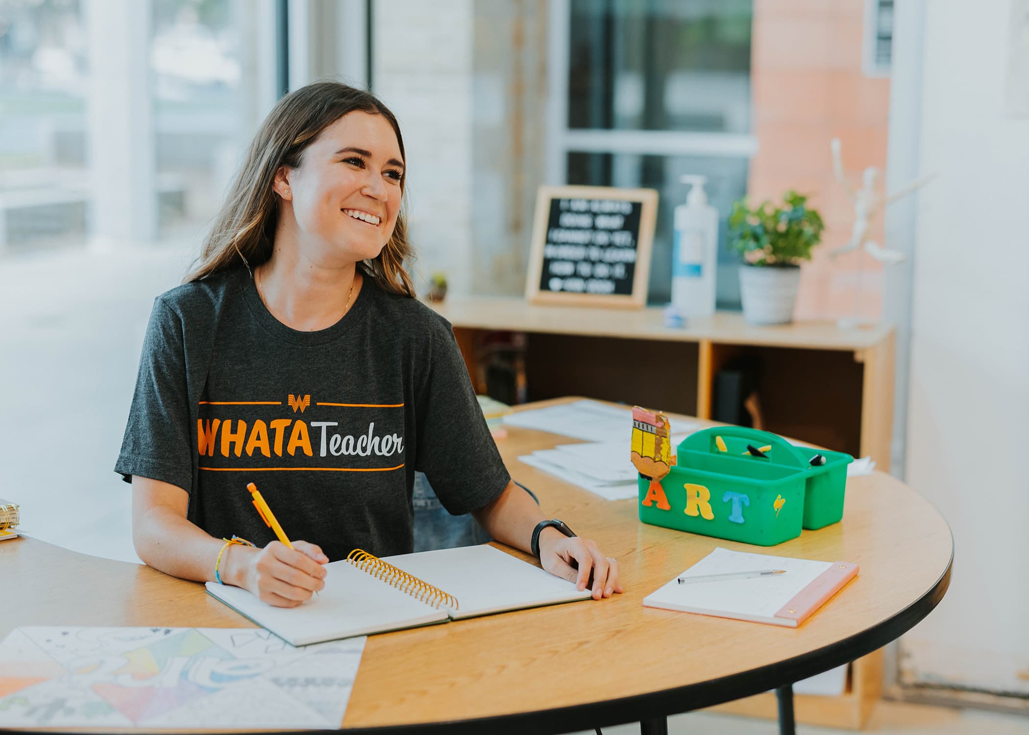 teacher wearing a whatateacher t-shirt