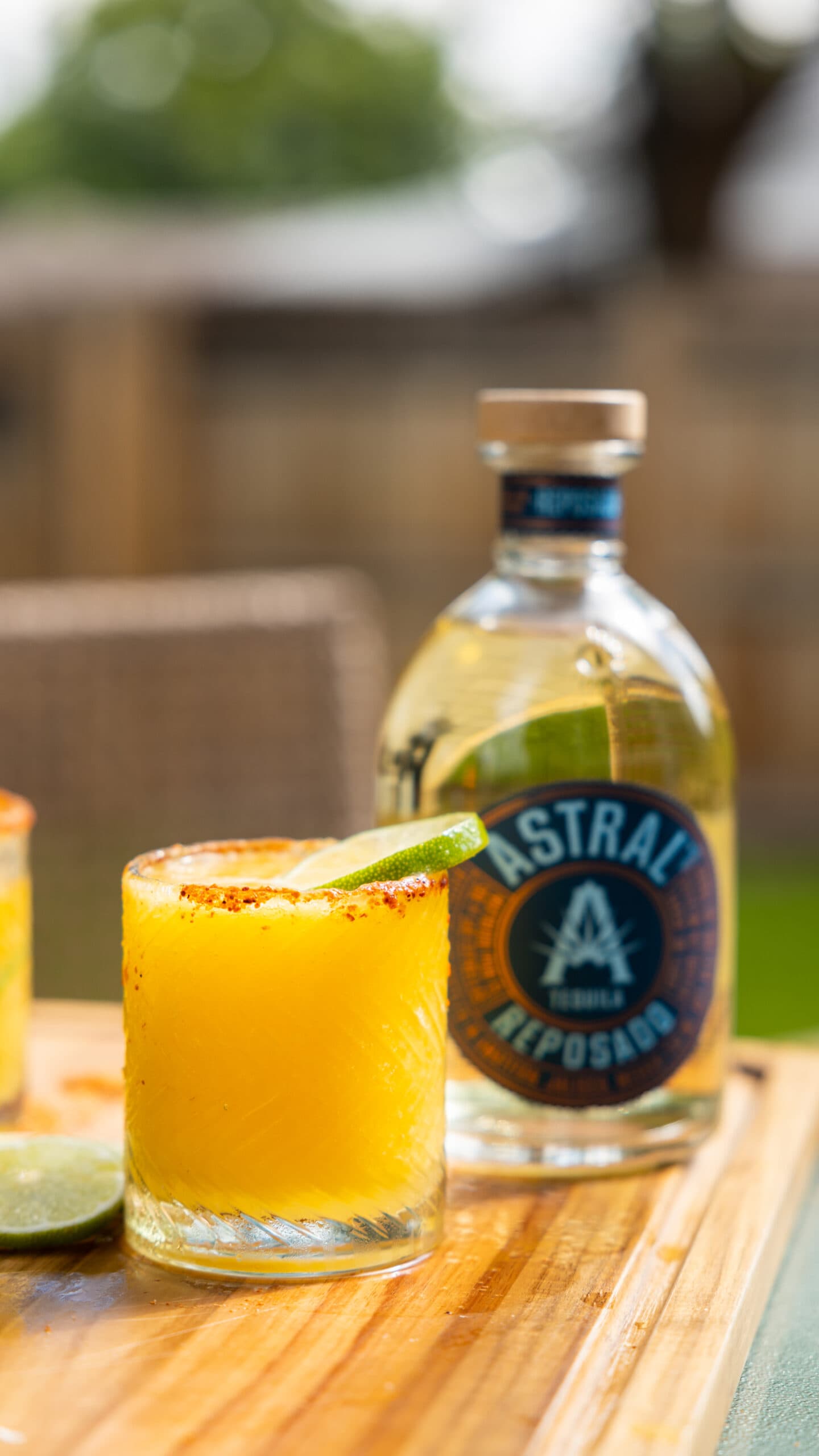 frozen mango margarita next to Astral tequila bottle