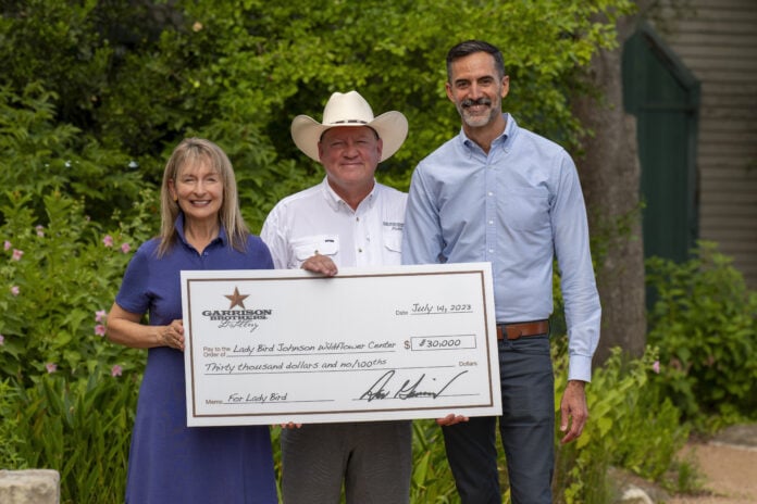 Nancy and Dan Garrison with Lee Clippard executive director of The University of Texas at Austin Lady Bird Johnson Wildflower Center Nancy and Dan Garrison with cardboard check