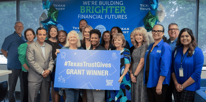 Texas Trust employees with carboard sign