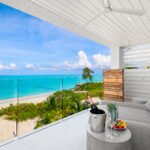 Escape To Beach Enclave Turks & Caicos For a Luxurious Getaway With Special Family Rates balcony overlooking beach with champagne