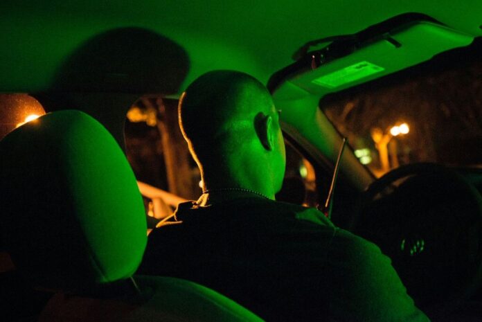 Conducting Surveillance in Operation Cross Country police officer in car at night