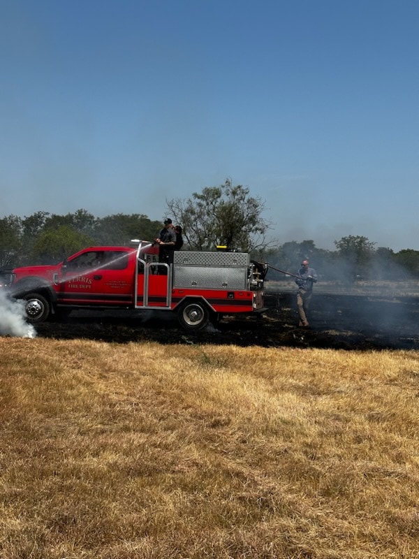 fire equipment putting out fire in field