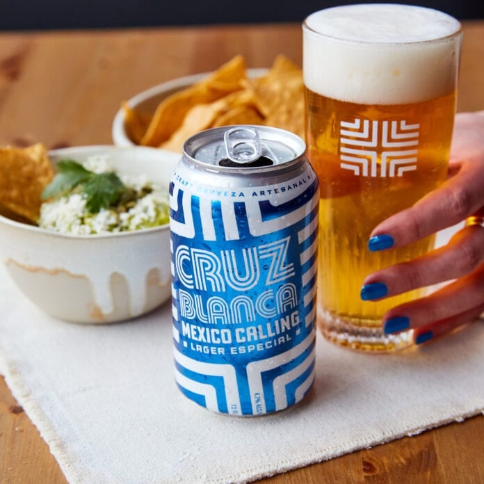 Cruz blanca beer can with pint glass and food
