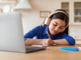 girl wearing headphones by laptop