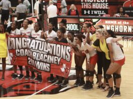 Cedar Hill volleyball players with congratulations banner