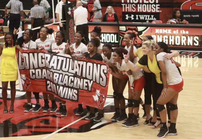 Cedar Hill volleyball players with congratulations banner