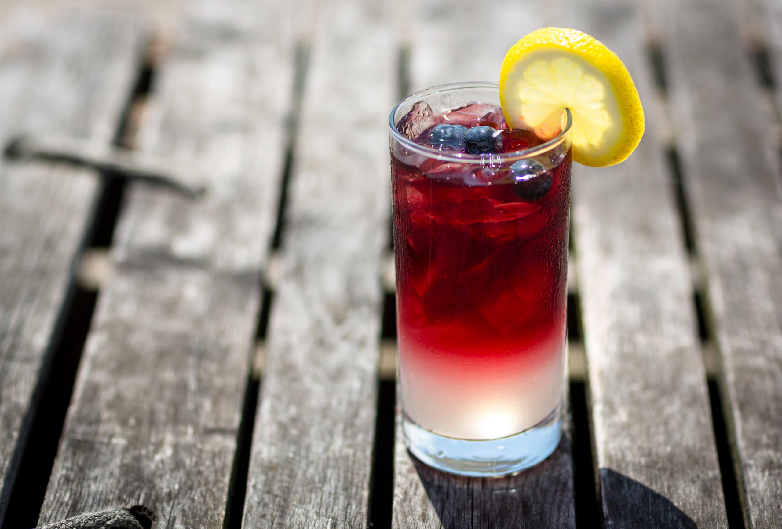 red and white cocktail in highball glass