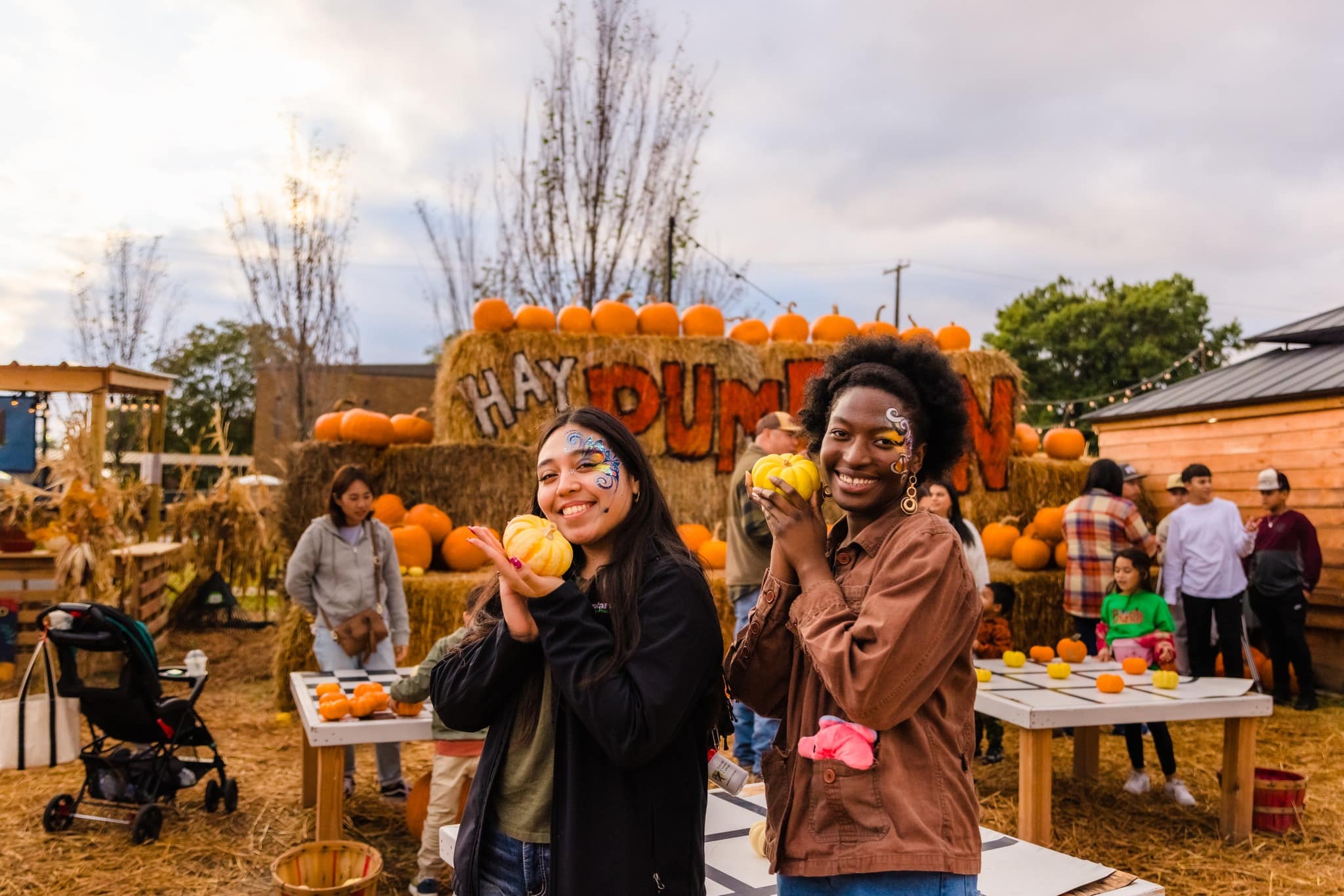 two ladies holding small pumpkins