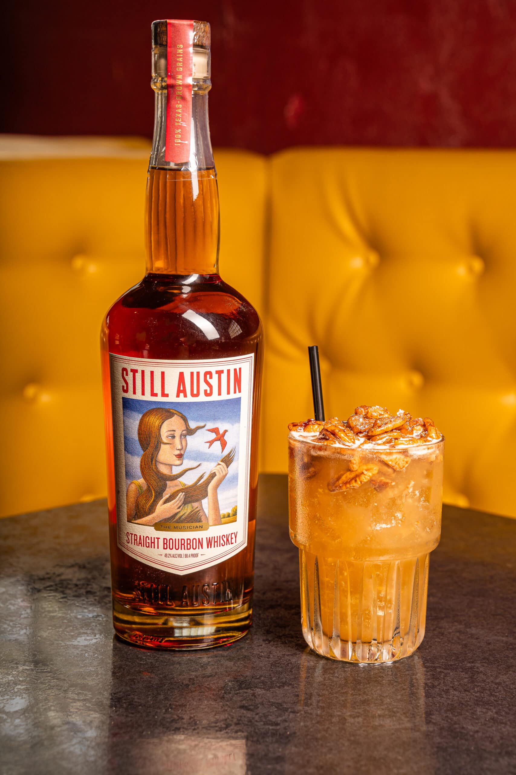 pumpkin spice cocktail next to Still Austin whiskey bottle