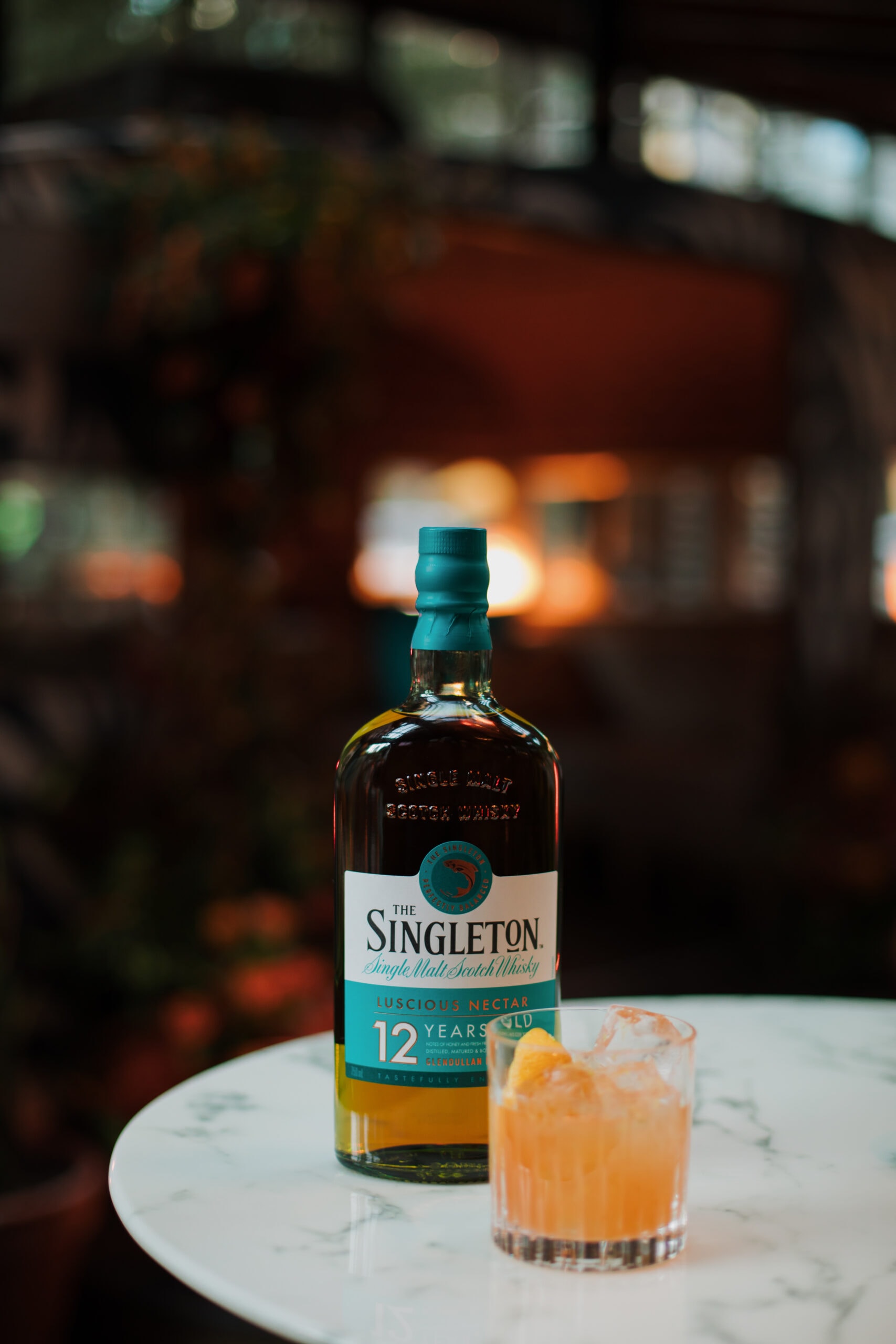 cider cocktail with bottle of Singleton whiskey