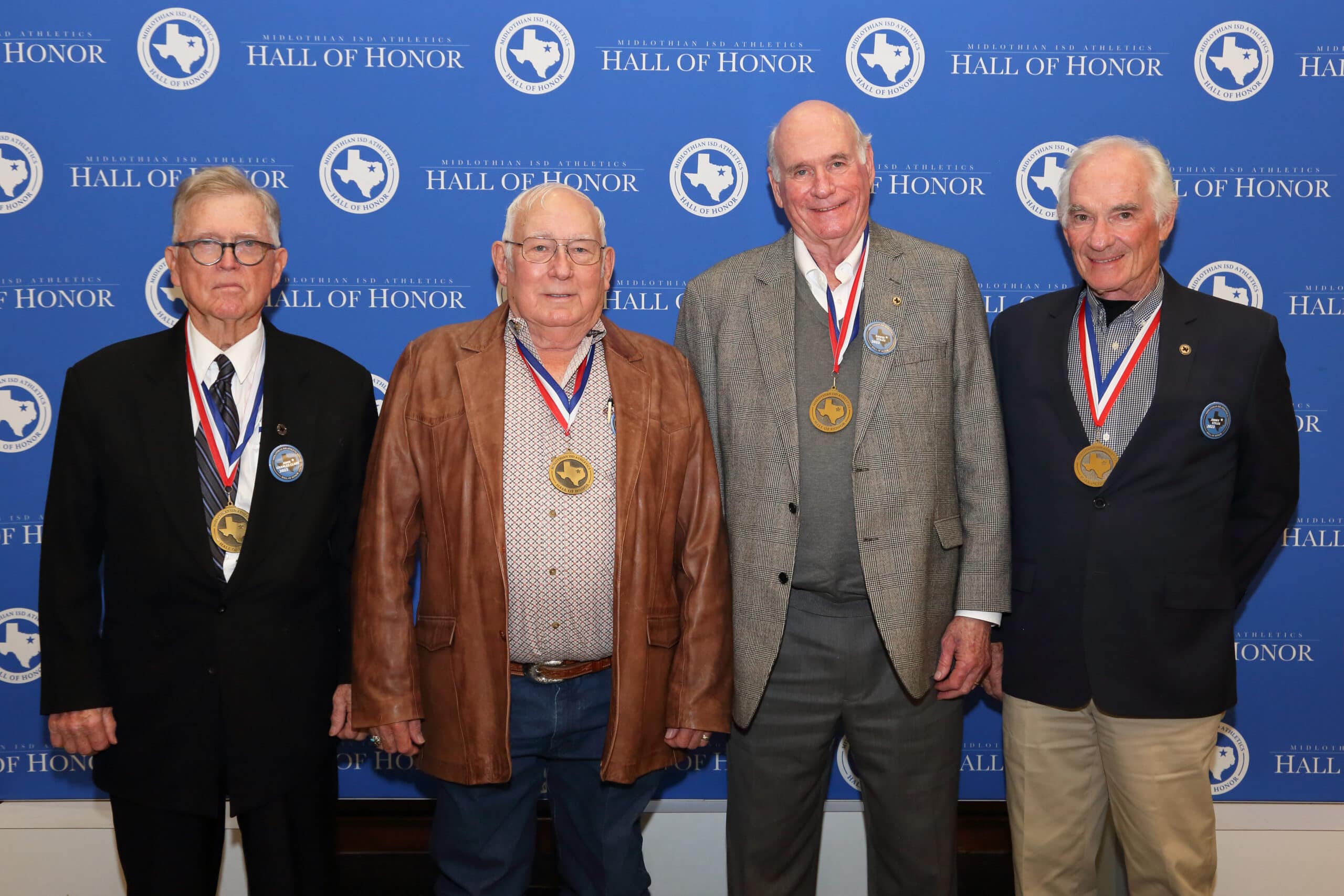 Four men wearing medals on their necks