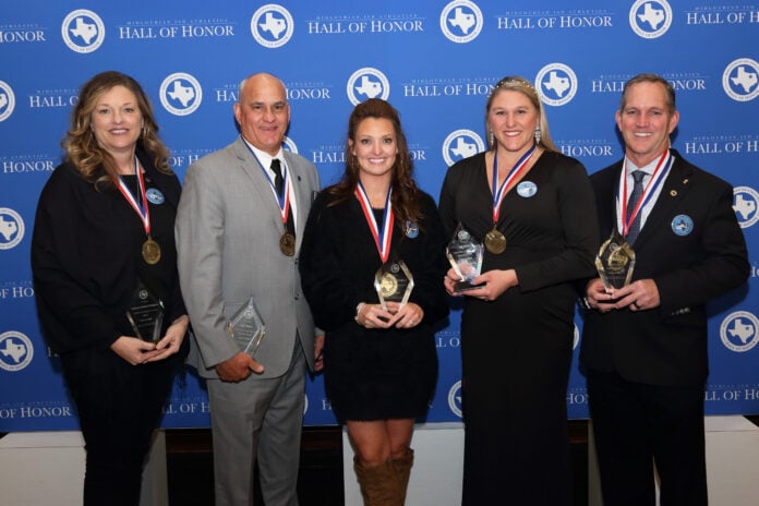 three ladies and two men standing with trophies