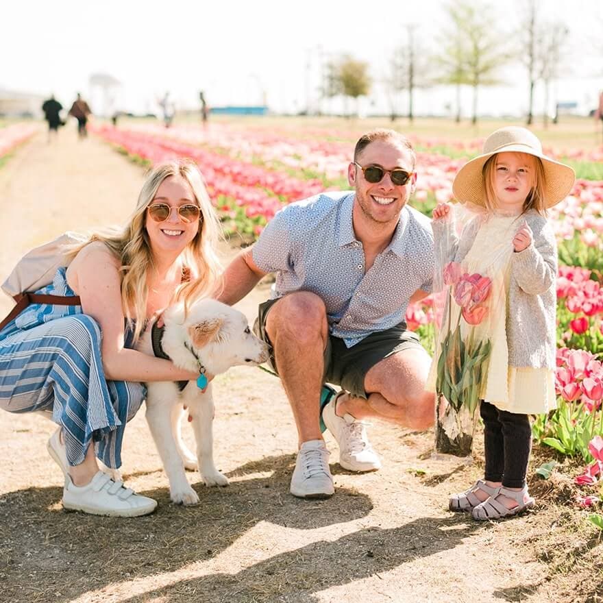 woman with dog man and little girl in field