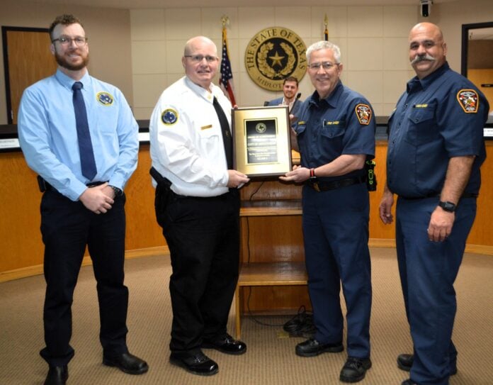 four men holding a certificate