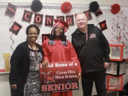 man and woman with student in graduation gown