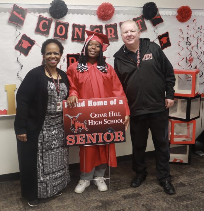 man and woman with student in graduation gown