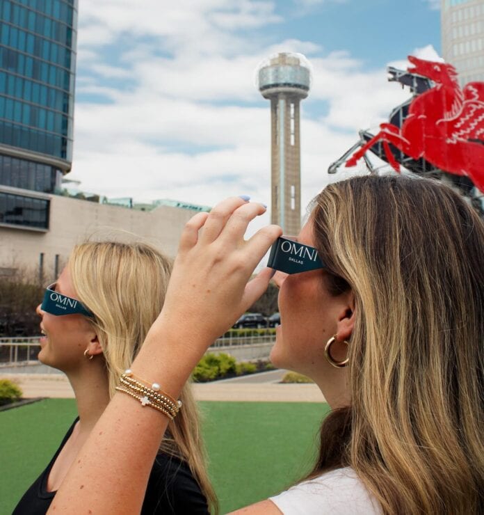 women wearning eclipse glasses