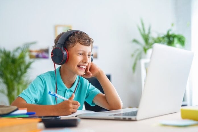 kid at desk wearing headphones
